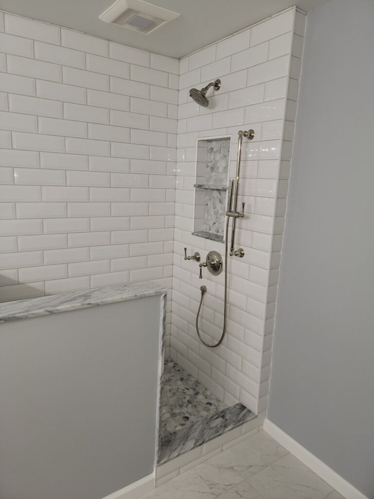 Beveled Subway Shower with Marble bench and mosaic shower floor